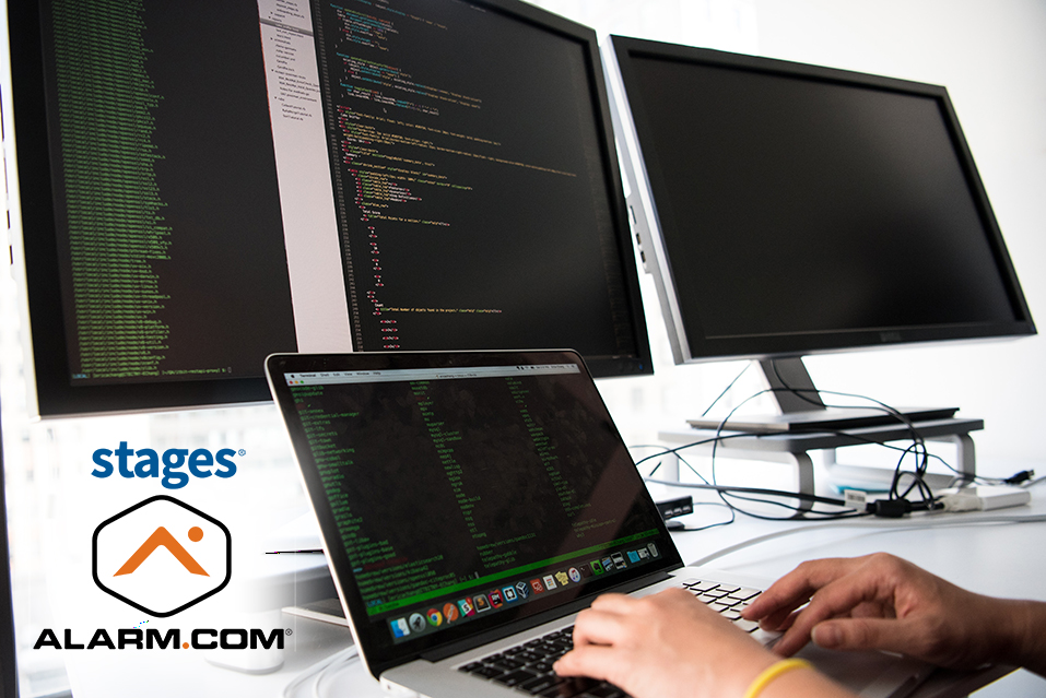 a stack of computers on a desk with someone working at one.