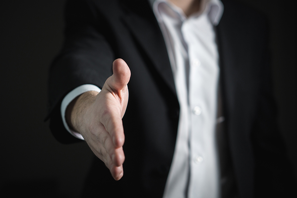 a person looking to shake the other persons hand