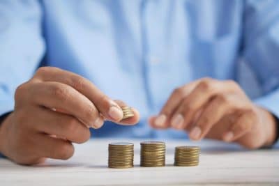 a person stacking up coins on a table