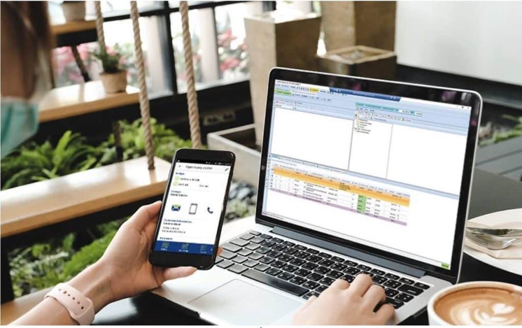 a person using a mobile device in front of a computer