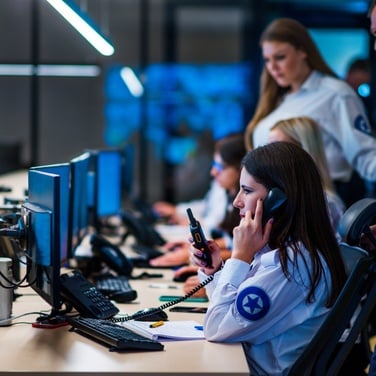 Security operations center staff monitoring systems and coordinating response at computer workstations.